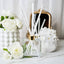 Diffuser with reeds and decorative flowers on a marble surface