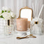 Decorative items including a candle, diffuser, and flowers on a white surface with a mirror in the background.