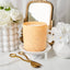 Decorative candle on a marble surface with white flowers and a mirror in the background