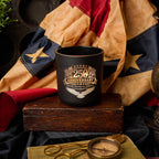 Black mug with '250 Anniversary' design on a wooden block with American flag in background