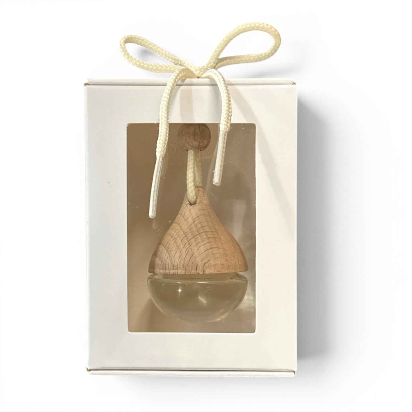 Wooden hanging decor item in a clear box with a white ribbon on a white background