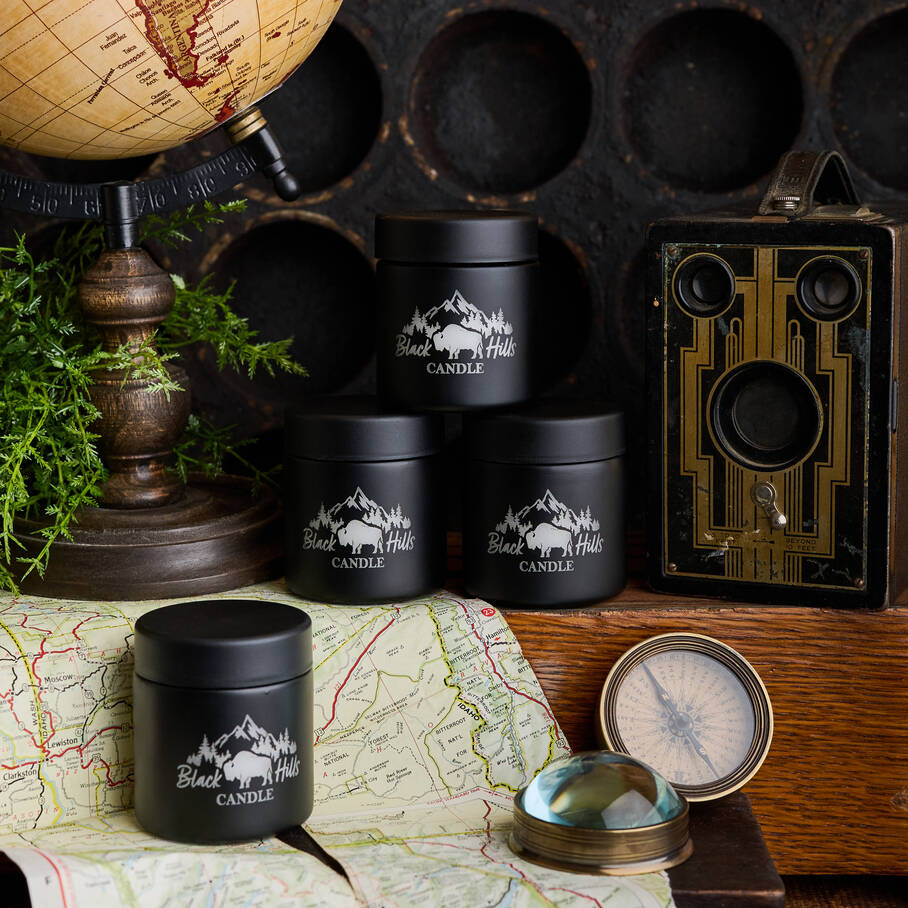 Black candle containers with mountain design on a map with vintage items