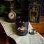 Black candle with 'Black Hills Candle' logo on a map with vintage items around