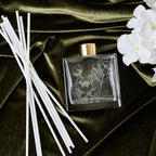 Decorative diffuser with floral design on a dark fabric background