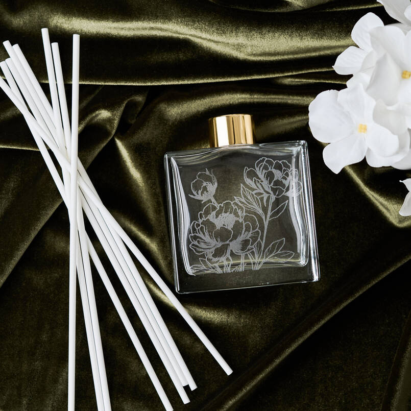 Decorative diffuser with floral design on a dark fabric background
