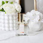Perfume bottle labeled 'Morning Light' with white flowers in the background