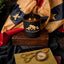 Candle with Mount Rushmore design on a wooden block, surrounded by vintage items like scissors and a compass, with a flag in the background.