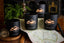 Black candles with mountain design on a wooden surface with a map
