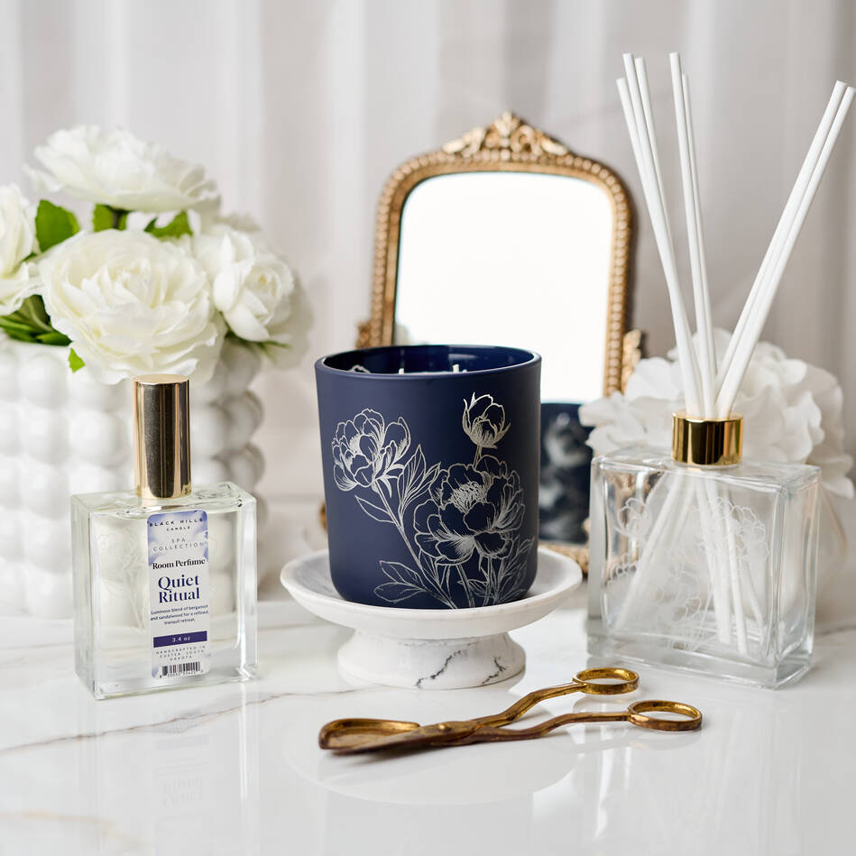 Decorative items including a blue candle, flowers, and diffuser on a white surface. Main image