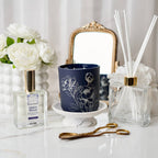 Decorative items including a blue candle, flowers, and diffuser on a white surface.