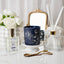 Decorative items including a blue candle, flowers, and diffuser on a white surface.