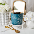 Blue candle with floral design on a white surface with decorative items