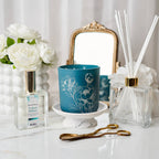 Decorative items including a blue candle, diffuser, and flowers on a white surface.