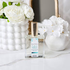 Perfume bottle labeled 'Velvet Solace' with white flowers in the background