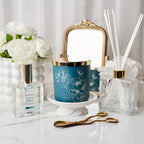 Decorative items including a blue candle, diffuser, and flowers on a white surface.